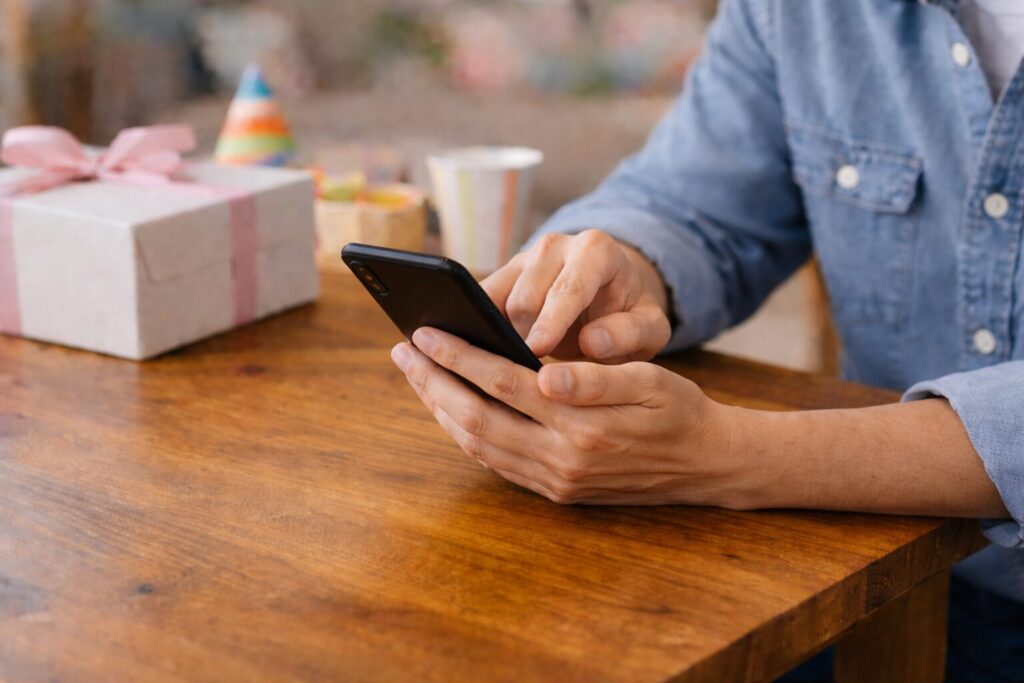 スマートフォンで誕生日ケーキを注文する日本人の親の手元